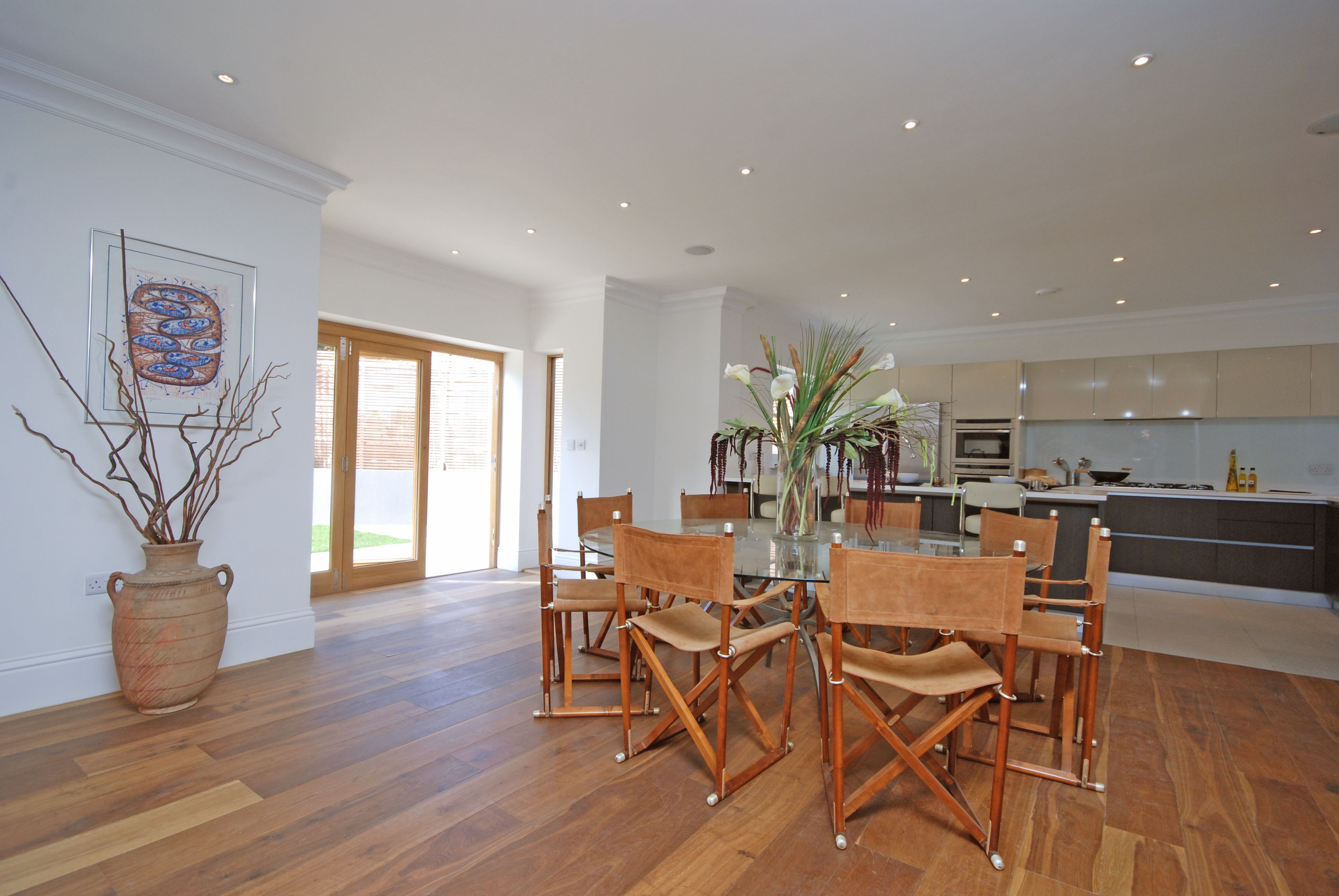 Open-plan dining area with oak flooring and bi-fold doors to the garden