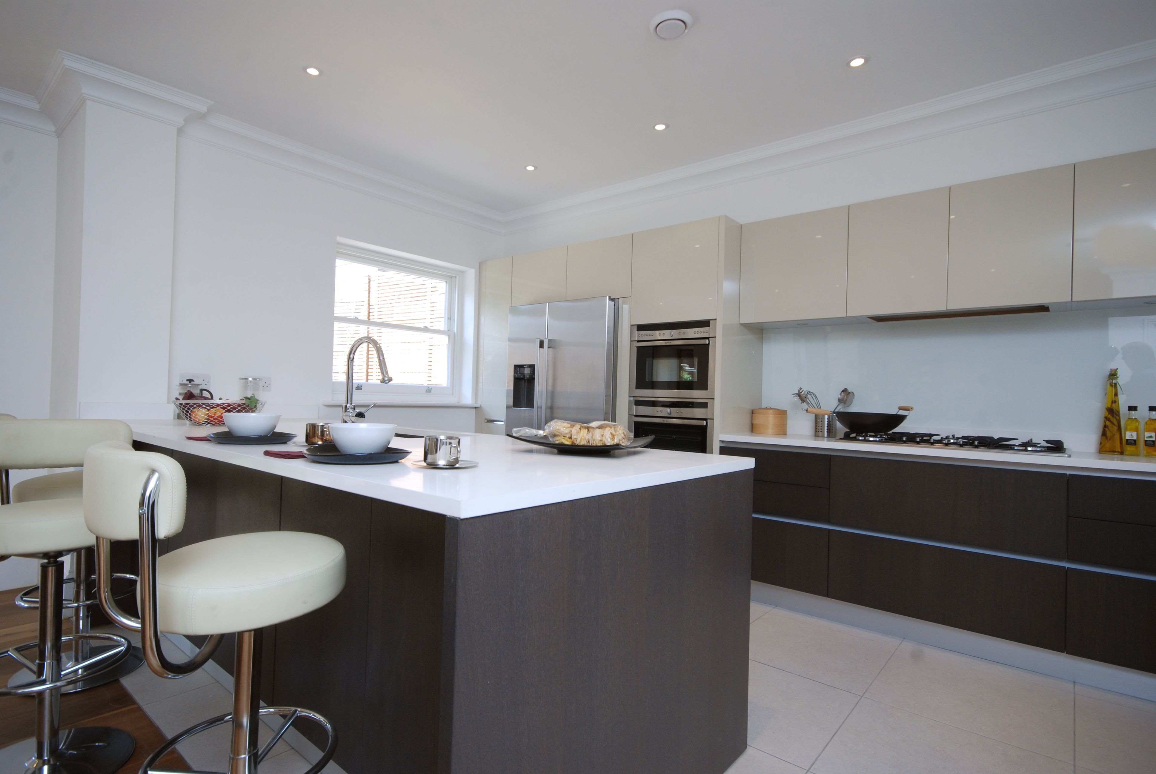 Modern kitchen with island, integrated appliances and stone worktops