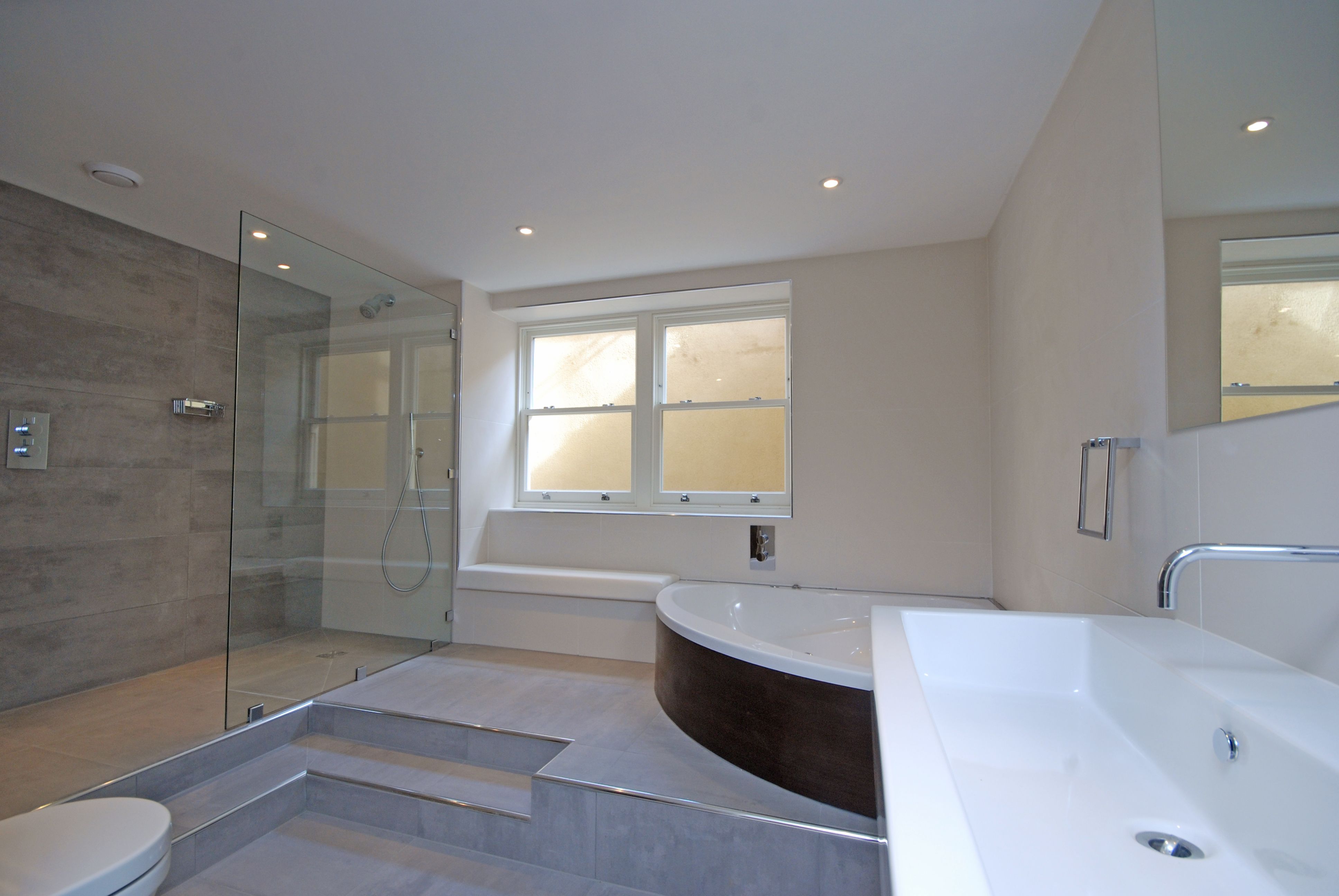 Master bathroom with walk-in shower, freestanding bath and stone tiling